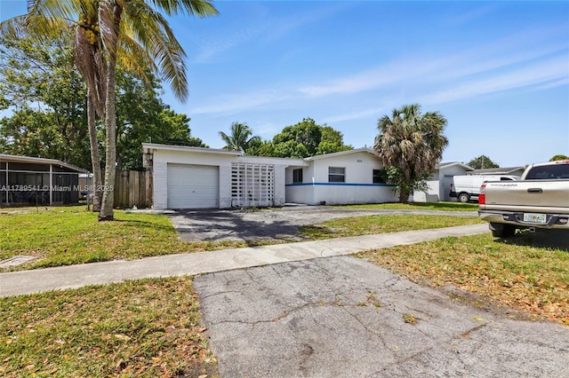4210 NW 23rd St, Lauderhill, FL 33313 - view of front of home with an attached garage, driveway, fence, and a front yard