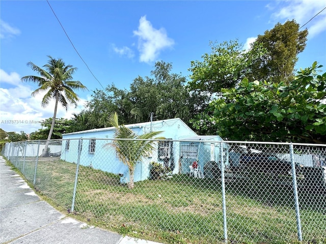 view of home's exterior featuring fence and a lawn