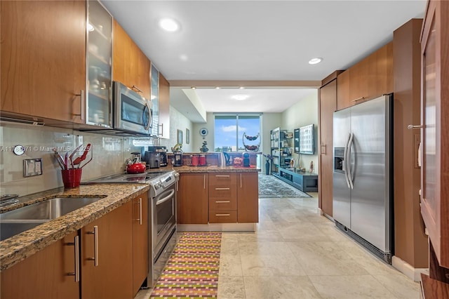 1945 S Ocean Dr Unit 401, Hallandale Beach, FL 33009 - kitchen featuring appliances with stainless steel finishes, a peninsula, dark stone countertops, brown cabinets, and recessed lighting