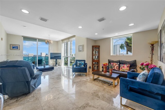 living area featuring marble finish floor, visible vents, an inviting chandelier, and floor to ceiling windows