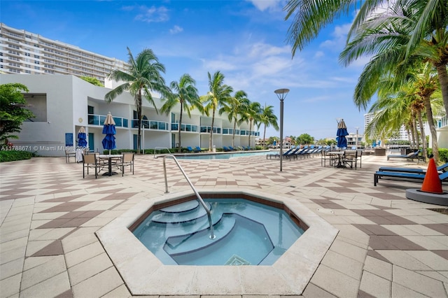 community pool featuring a hot tub and a patio