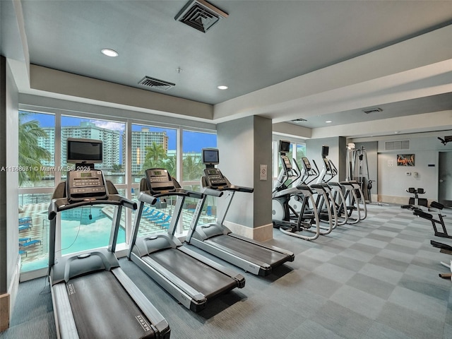 gym with visible vents, carpet flooring, and a wealth of natural light