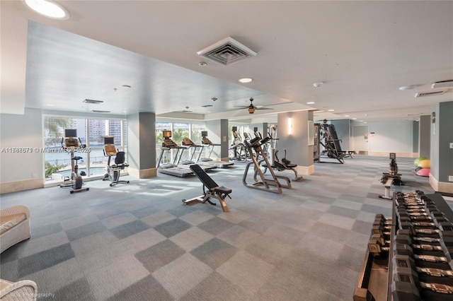 gym with visible vents, light carpet, baseboards, and ceiling fan