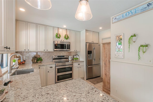 11430 NW 39th Ct, Coral Springs, FL 33065 - kitchen with a wainscoted wall, light stone counters, stainless steel appliances, backsplash, and a sink