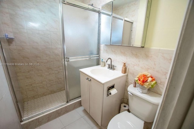 full bathroom with toilet, vanity, tile patterned floors, and a stall shower