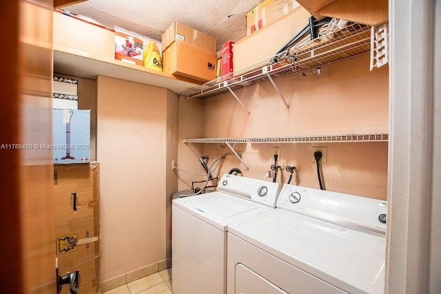 clothes washing area featuring washing machine and dryer, laundry area, and light tile patterned floors