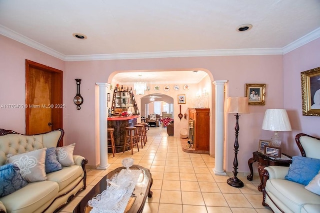 living area with ornate columns, ornamental molding, light tile patterned floors, arched walkways, and baseboards