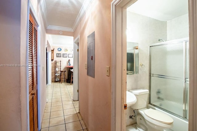 bathroom featuring electric panel, tile patterned floors, toilet, crown molding, and enclosed tub / shower combo