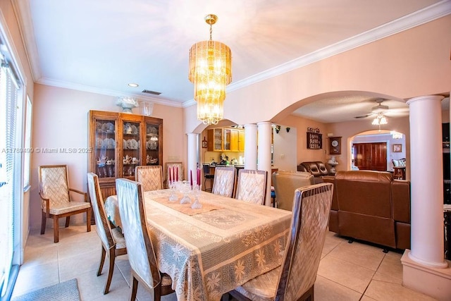 dining room with ceiling fan with notable chandelier, light tile patterned flooring, arched walkways, visible vents, and decorative columns