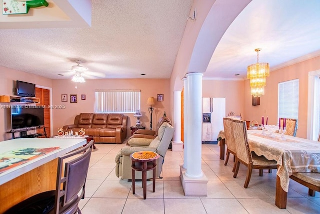 dining area featuring light tile patterned flooring, ceiling fan with notable chandelier, arched walkways, and decorative columns