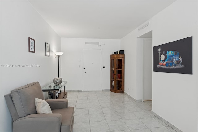 interior space featuring baseboards, visible vents, and light tile patterned floors