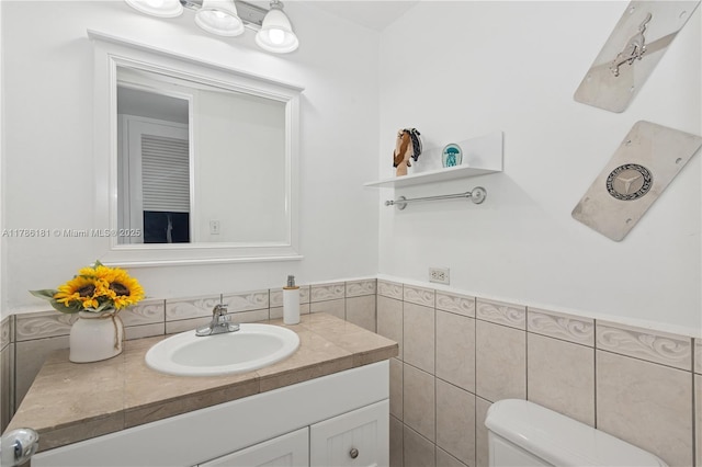 5055 Collins Ave Unit 5F, Miami Beach, FL 33140 - half bath with vanity, tile walls, and wainscoting
