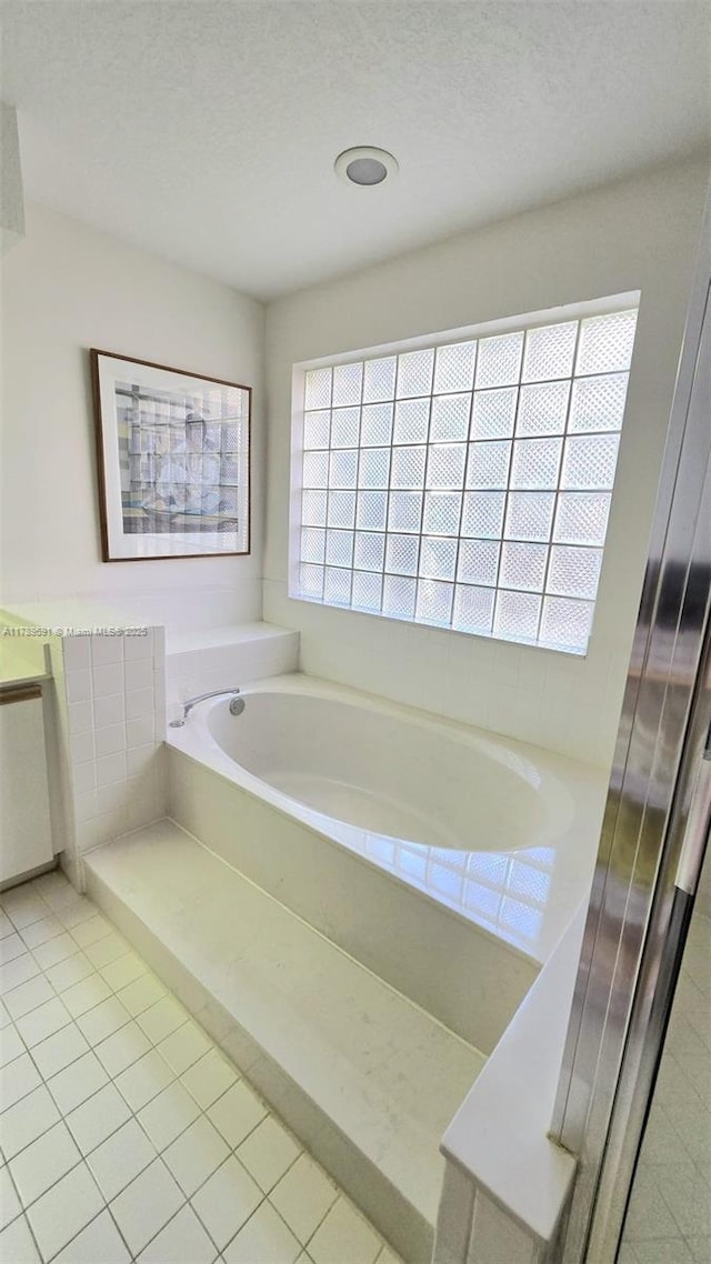 10132 NW 4th, Plantation, FL 33324 - bathroom featuring a textured ceiling, a garden tub, and tile patterned floors