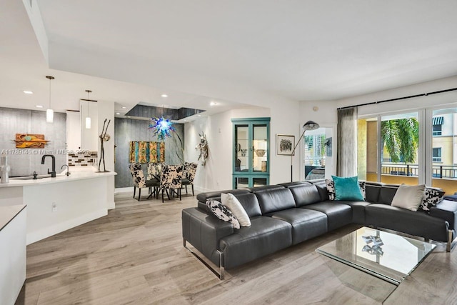 living area featuring recessed lighting, baseboards, and light wood finished floors