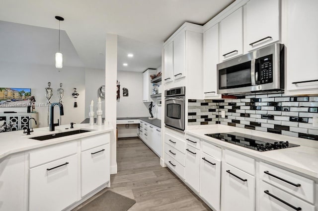 16101 Emerald Estates Dr Unit 342, Weston, FL 33331 - kitchen with light wood finished floors, a sink, stainless steel appliances, white cabinetry, and backsplash