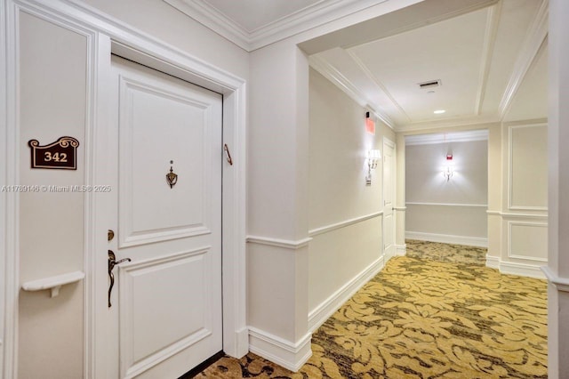 hall featuring crown molding, baseboards, light carpet, and visible vents