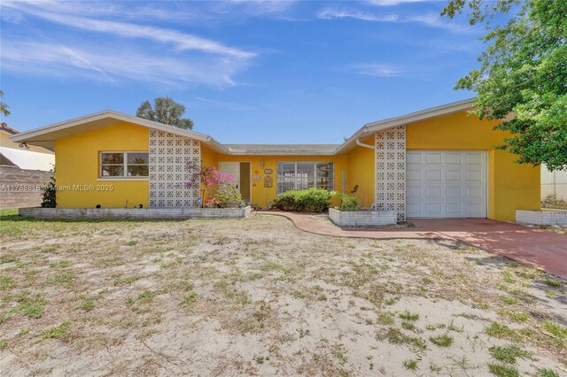 view of front of home with an attached garage, concrete driveway, and stucco siding