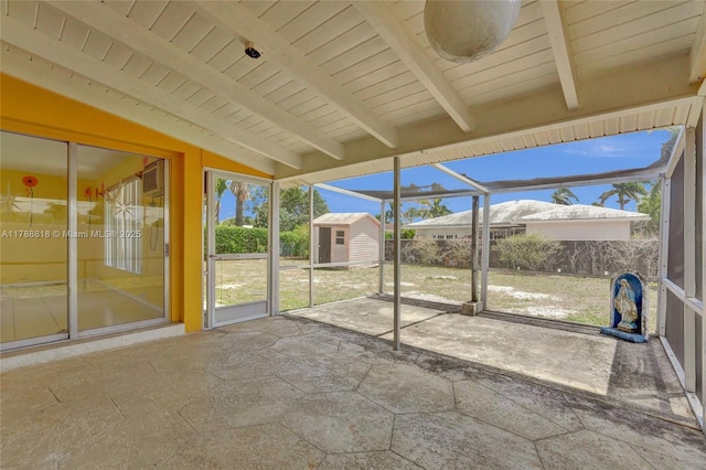 unfurnished sunroom with beamed ceiling