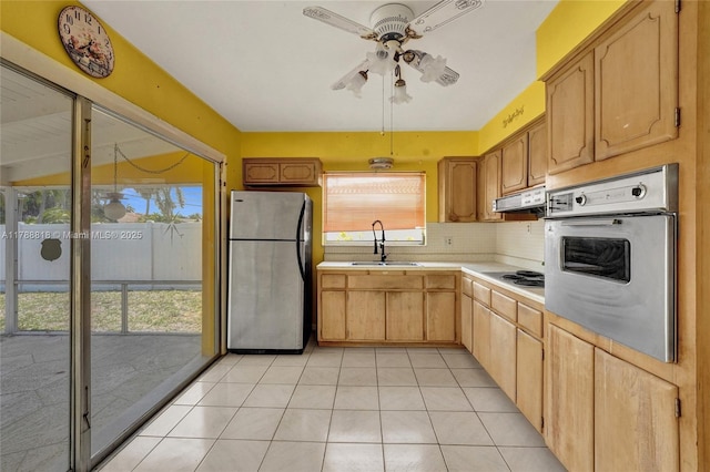kitchen with a sink, decorative backsplash, ceiling fan, light countertops, and appliances with stainless steel finishes