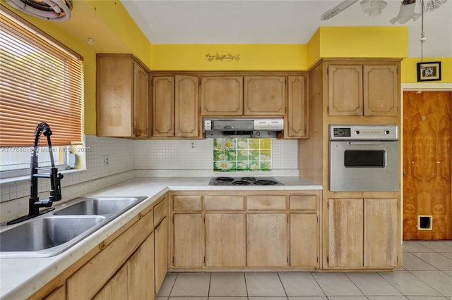 kitchen featuring light countertops, a sink, light tile patterned flooring, wall oven, and black electric stovetop
