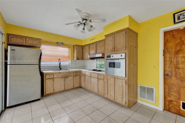 kitchen with a sink, visible vents, light countertops, under cabinet range hood, and appliances with stainless steel finishes