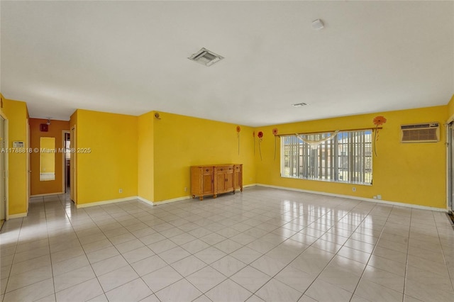 unfurnished room with baseboards, visible vents, a wall mounted AC, and light tile patterned floors