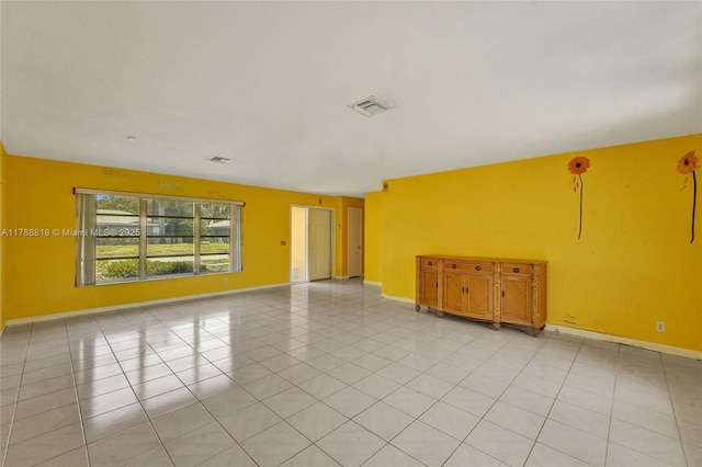 empty room featuring baseboards and visible vents
