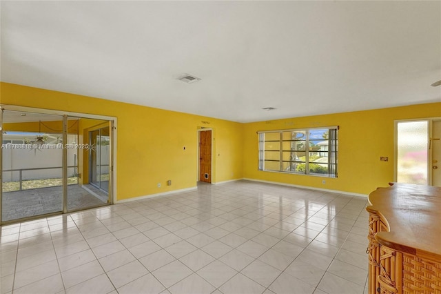 unfurnished room with visible vents, baseboards, and a wealth of natural light