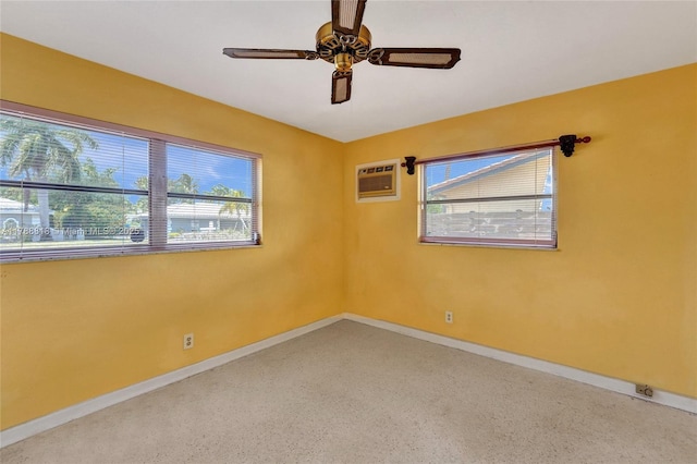 empty room featuring ceiling fan, baseboards, speckled floor, and a wall unit AC