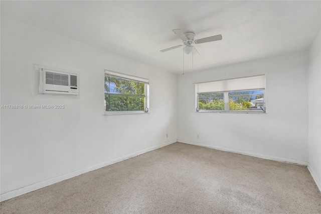 spare room featuring a wall mounted air conditioner, baseboards, and ceiling fan