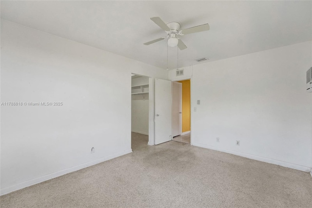 empty room featuring speckled floor, ceiling fan, baseboards, and visible vents