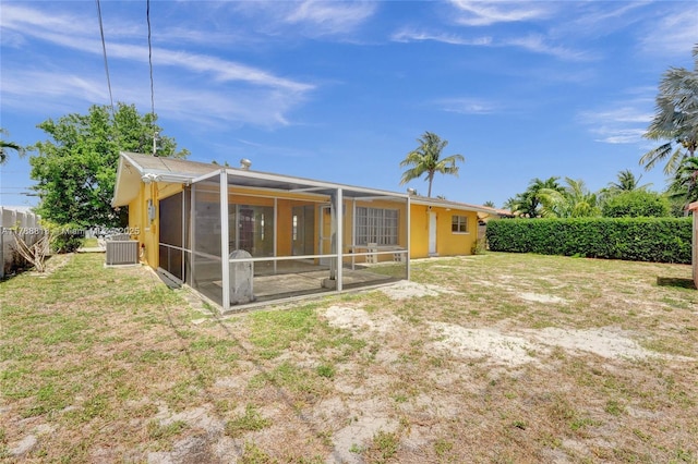 back of house with a sunroom, a yard, and cooling unit