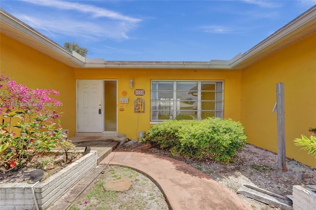 view of exterior entry with stucco siding