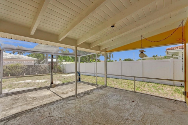 unfurnished sunroom featuring beam ceiling