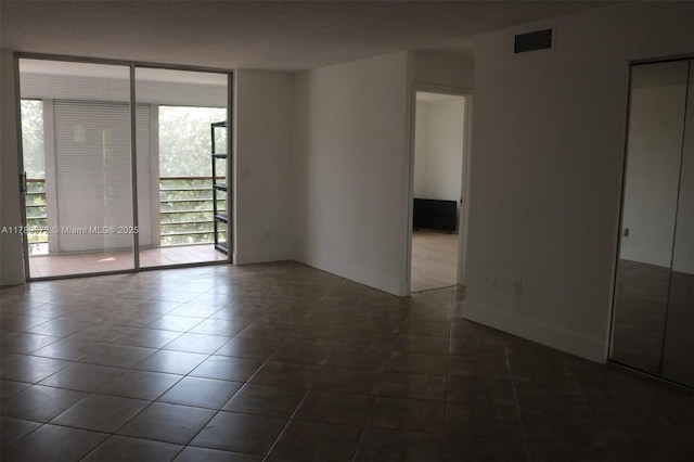 3490 Foxcroft Rd Unit B304, Miramar, FL 33025 - unfurnished room featuring dark tile patterned flooring, floor to ceiling windows, and baseboards