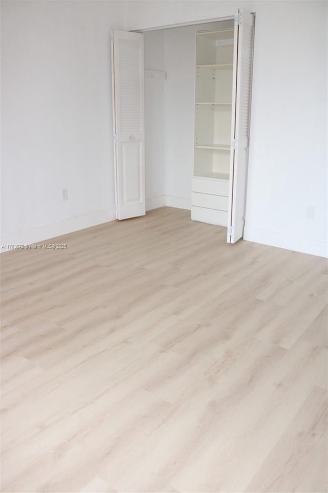 3490 Foxcroft Rd Unit B304, Miramar, FL 33025 - unfurnished bedroom featuring wood finished floors, baseboards, and a closet