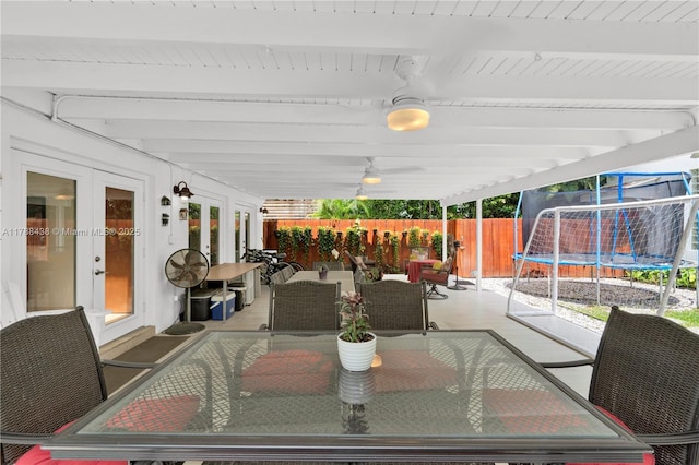 3730 Kumquat Ave, Miami, FL 33133 - view of patio / terrace with fence, french doors, outdoor dining space, and a trampoline
