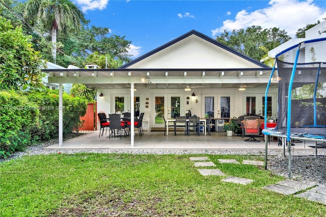 3730 Kumquat Ave, Miami, FL 33133 - rear view of property with a patio area, a trampoline, french doors, a yard, and stucco siding