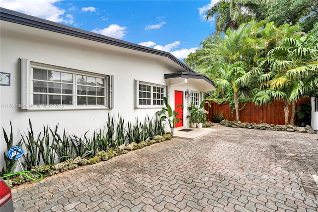 3730 Kumquat Ave, Miami, FL 33133 - property entrance featuring a patio, stucco siding, and fence