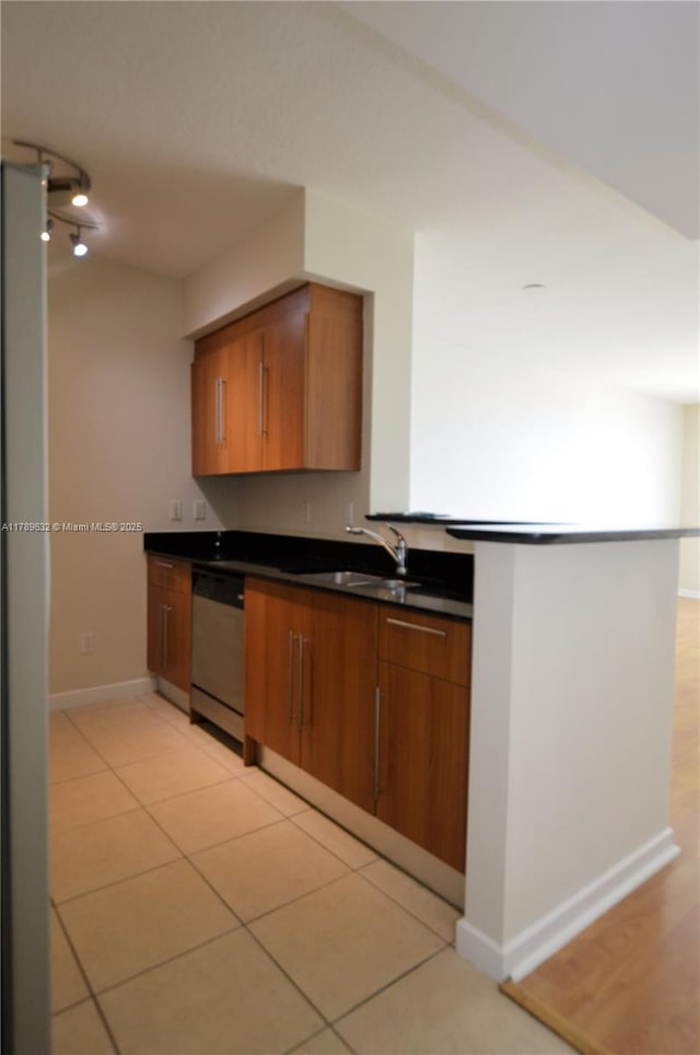 335 S Biscayne Blvd Unit 1904, Miami, FL 33131 - kitchen featuring stainless steel dishwasher, dark countertops, brown cabinetry, and light tile patterned flooring