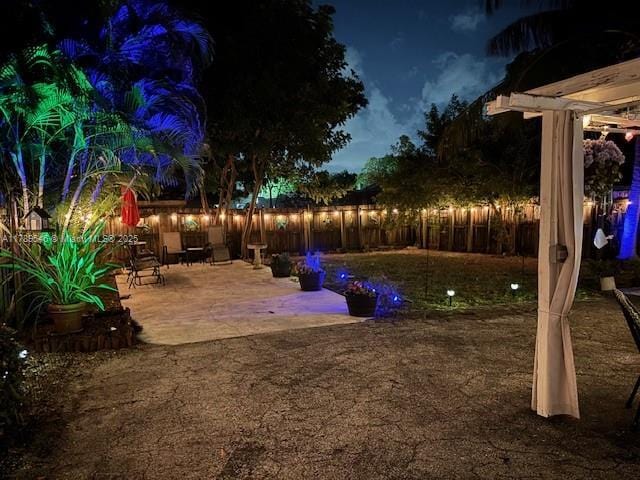 yard at twilight featuring a patio area and a fenced backyard