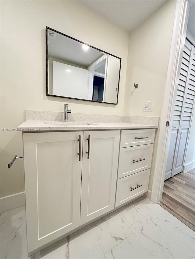 bathroom featuring marble finish floor, baseboards, and vanity