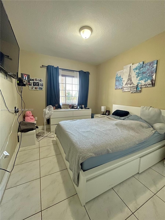 tiled bedroom featuring a textured ceiling