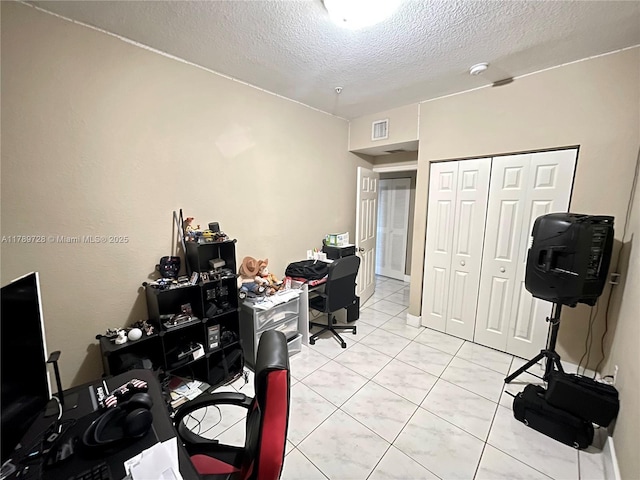 home office with visible vents, a textured ceiling, and light tile patterned flooring