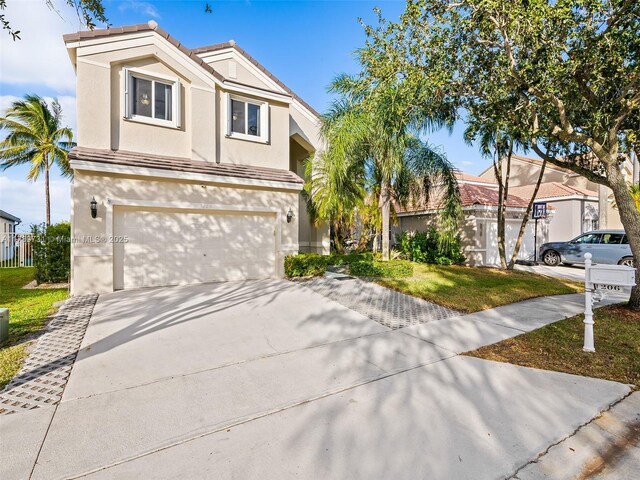 1206 Falls Blvd, Weston, FL 33327 - view of front of house with driveway, an attached garage, and stucco siding