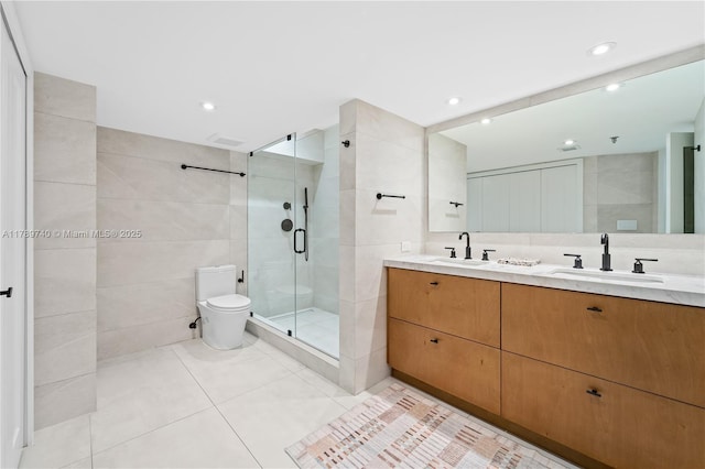 520 Brickell Key Dr Unit A713, Miami, FL 33131 - bathroom with tile walls, a shower stall, double vanity, tile patterned flooring, and toilet