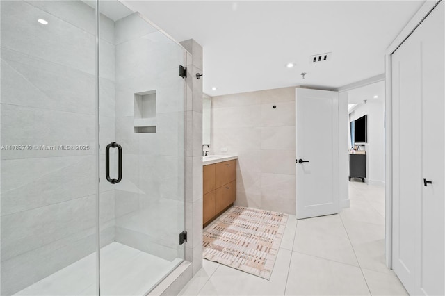 520 Brickell Key Dr Unit A713, Miami, FL 33131 - bathroom with a stall shower, tile patterned floors, vanity, and tile walls