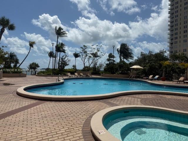 520 Brickell Key Dr Unit A713, Miami, FL 33131 - community pool with a patio area and a hot tub