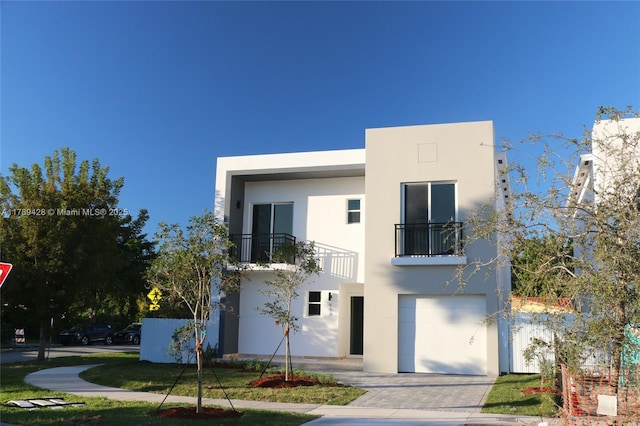 900 SW 24th Rd, Miami, FL 33129 - contemporary home featuring a garage, stucco siding, driveway, and a balcony