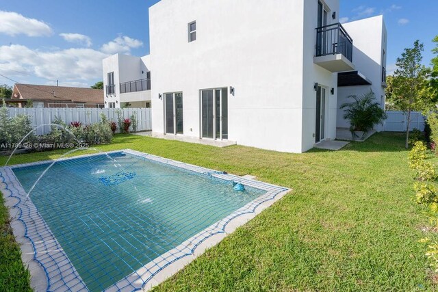 900 SW 24th Rd, Miami, FL 33129 - rear view of house featuring a fenced backyard, a swimming pool, stucco siding, and a yard